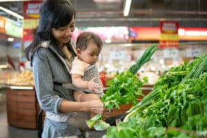 asian Mother and baby shopping in the supermarket. grocery store shopping