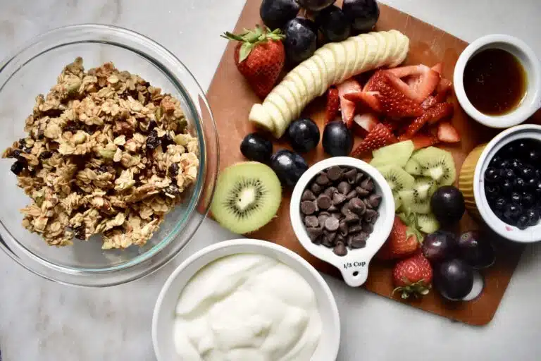 overhead view of parfait bar ingredients laid out - granola, fruit, and yogurt