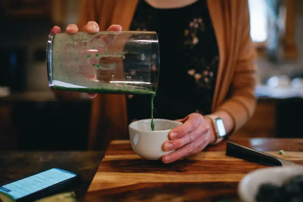 cropped image of woman pouring sauce into a white bowl