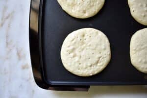 overhead of pancakes cooking on a griddle