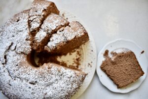 overhead view of chocolate pound cake with one slice on a plate and extra slices cut from cake